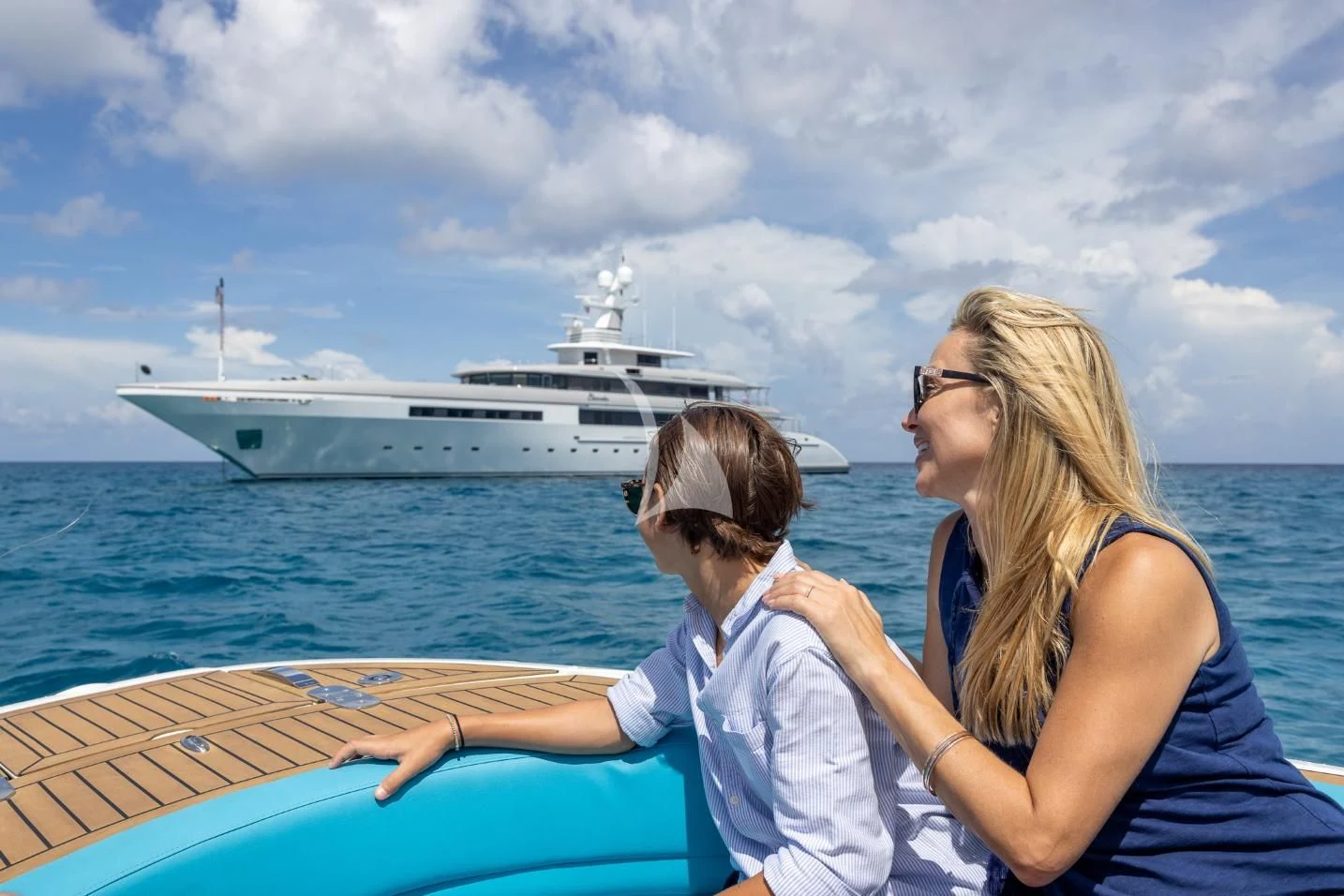 a woman and a child on a boat looking at a large ship in the distance aboard ETERNITY Yacht for Sale