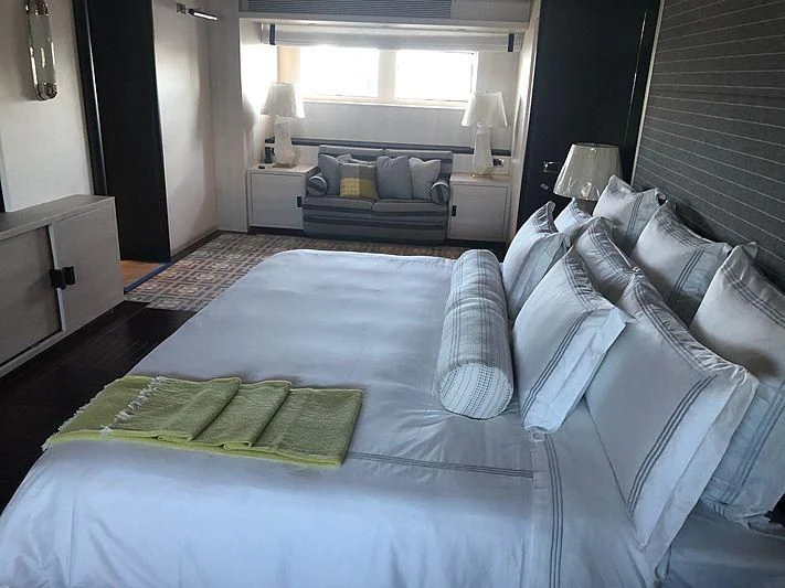 a bed with a blue comforter aboard ETERNITY Yacht for Sale