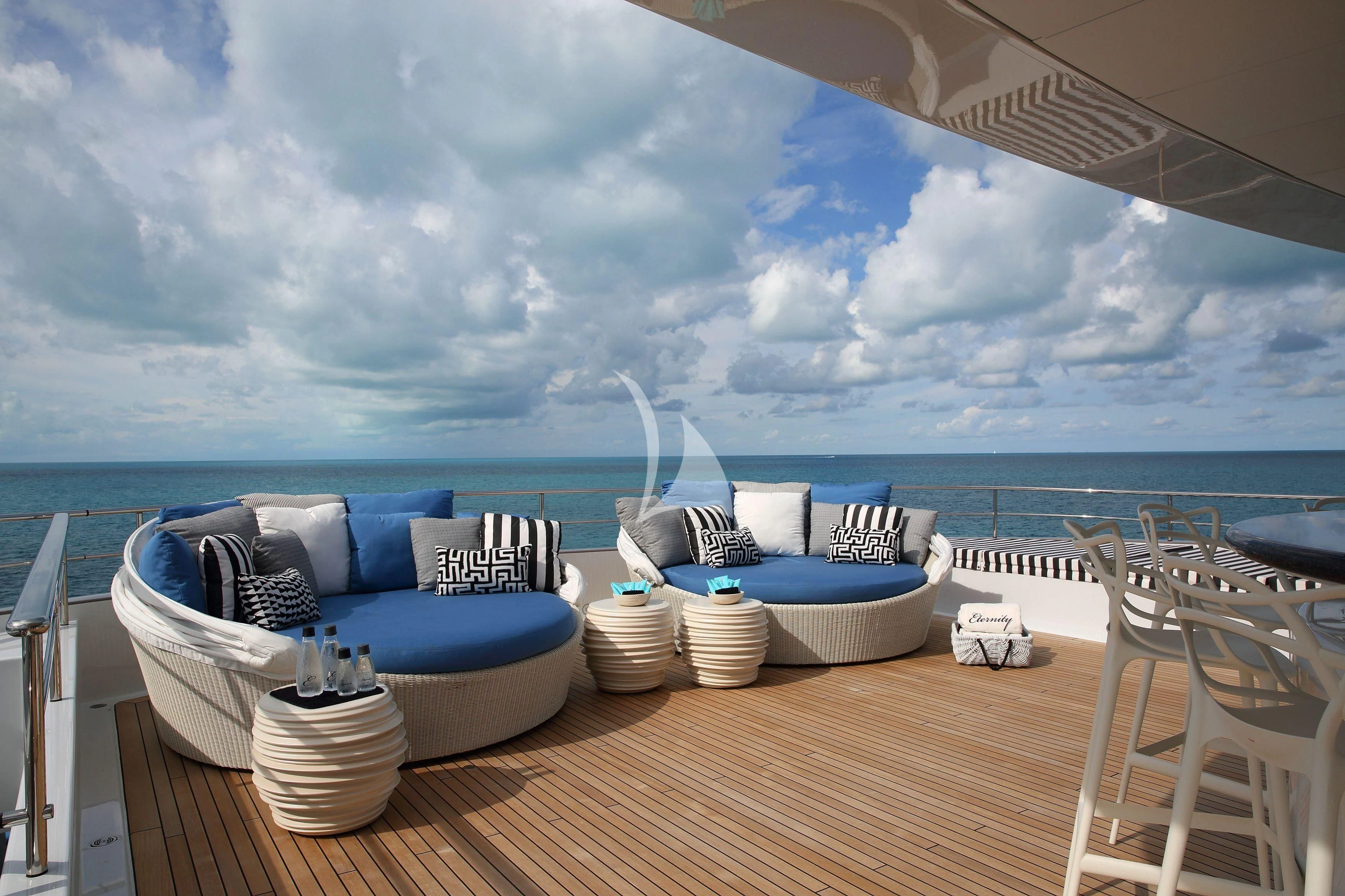 a table with chairs and a large body of water in the background aboard ETERNITY Yacht for Sale