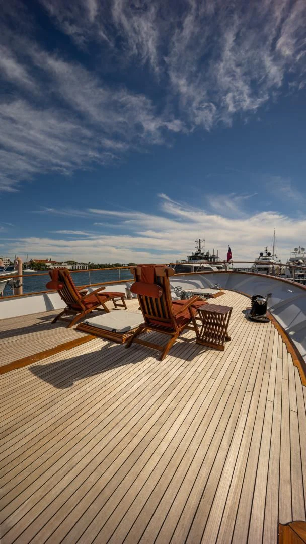 a deck with chairs and a table on it aboard SEA CZAR Yacht for Sale