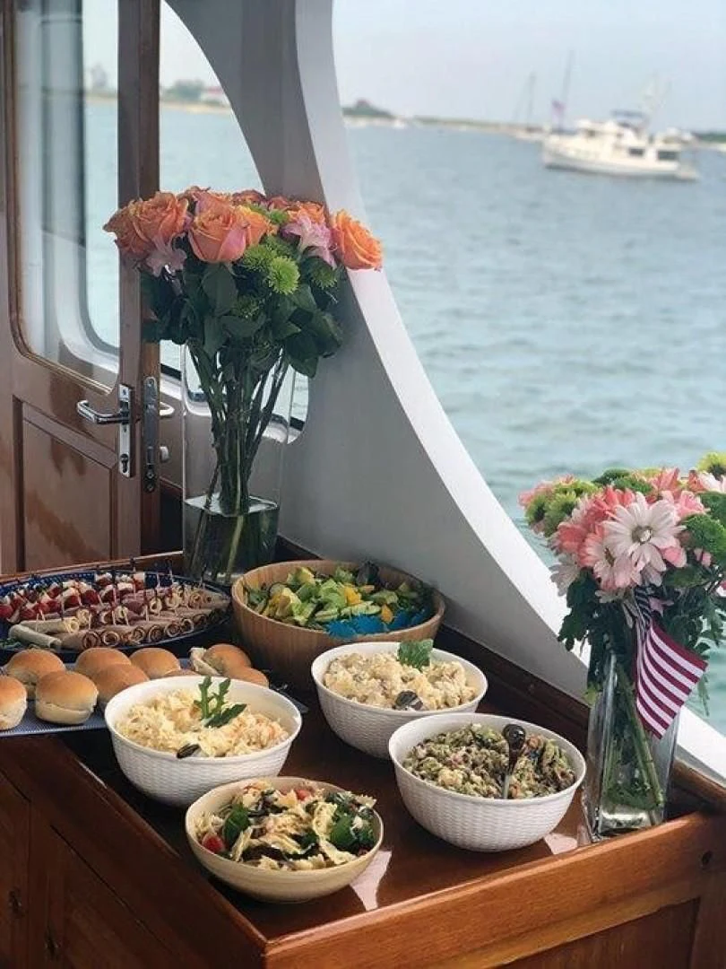 a table with food and a vase with flowers on it aboard SEA CZAR Yacht for Sale