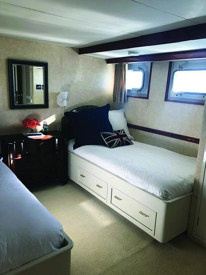a bedroom with a bed and a dresser aboard SEA CZAR Yacht for Sale