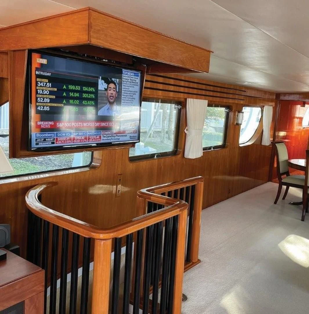 a room with a tv and chairs aboard SEA CZAR Yacht for Sale