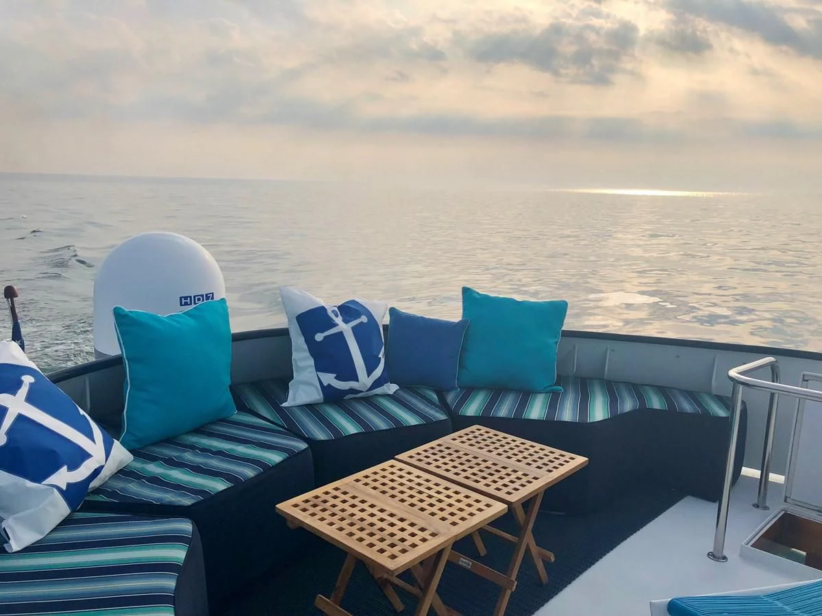 a deck with chairs and a body of water in the background aboard SEA CZAR Yacht for Sale