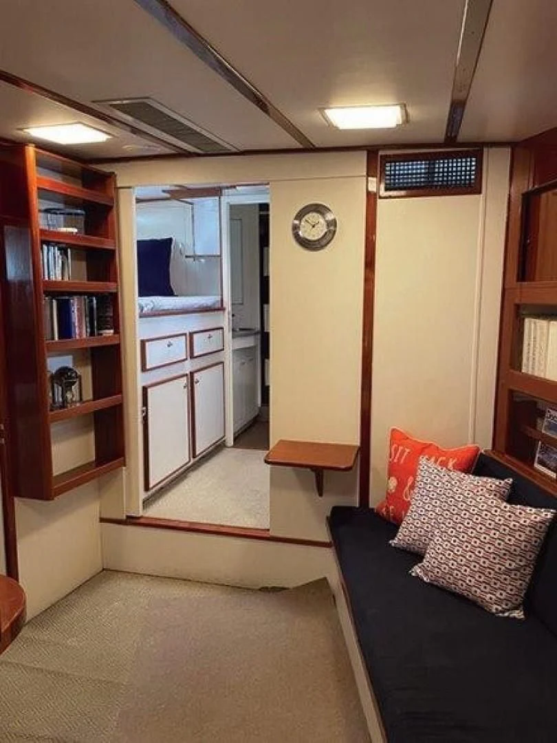 a living room with a couch and a bookcase aboard SEA CZAR Yacht for Sale