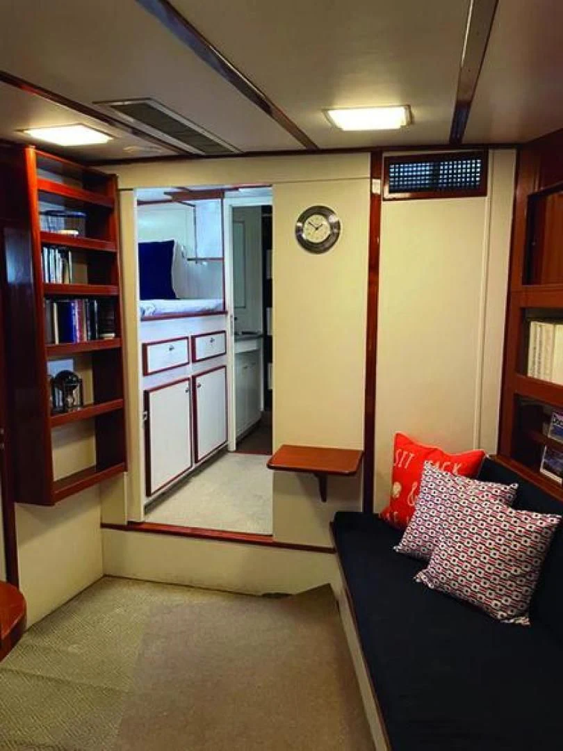 a living room with a bookcase aboard SEA CZAR Yacht for Sale