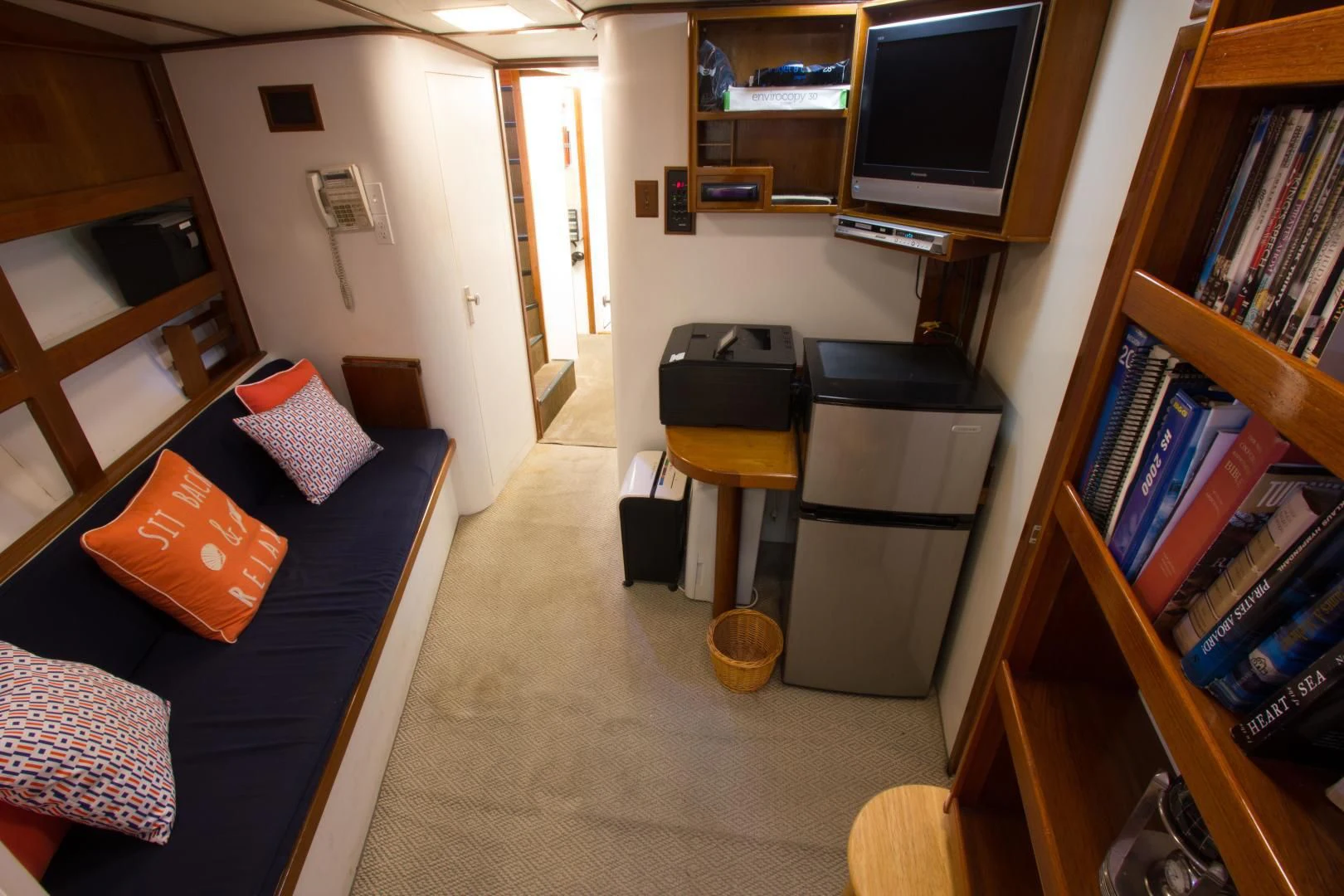 a living room with a blue couch and a television aboard SEA CZAR Yacht for Sale