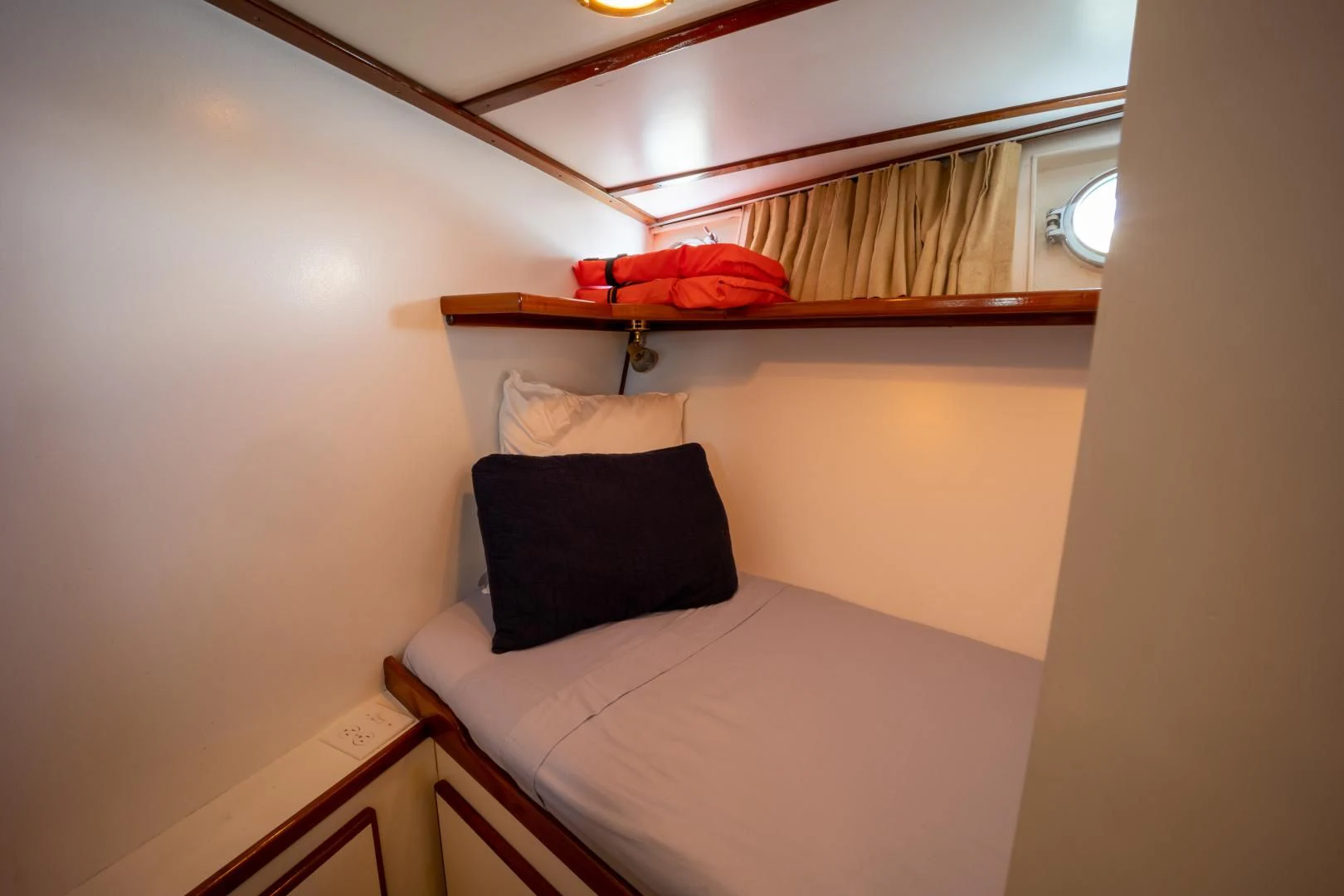 a bed with a red pillow aboard SEA CZAR Yacht for Sale