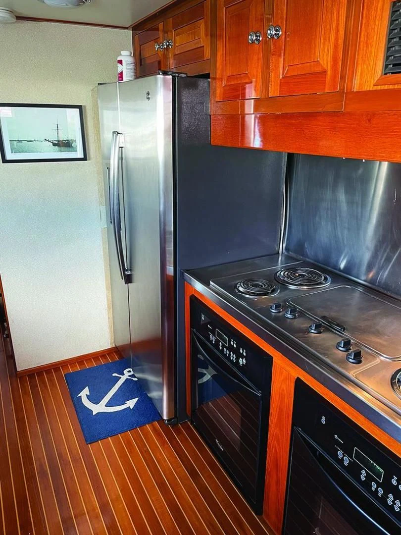 a kitchen with a stove and refrigerator aboard SEA CZAR Yacht for Sale