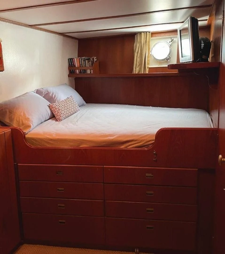 a bed with a wooden headboard aboard SEA CZAR Yacht for Sale