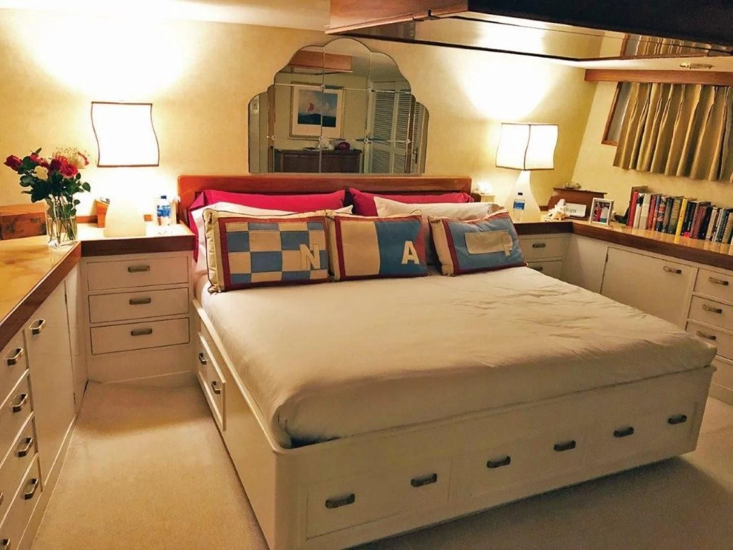 a bed with a red and blue pillow on it aboard SEA CZAR Yacht for Sale