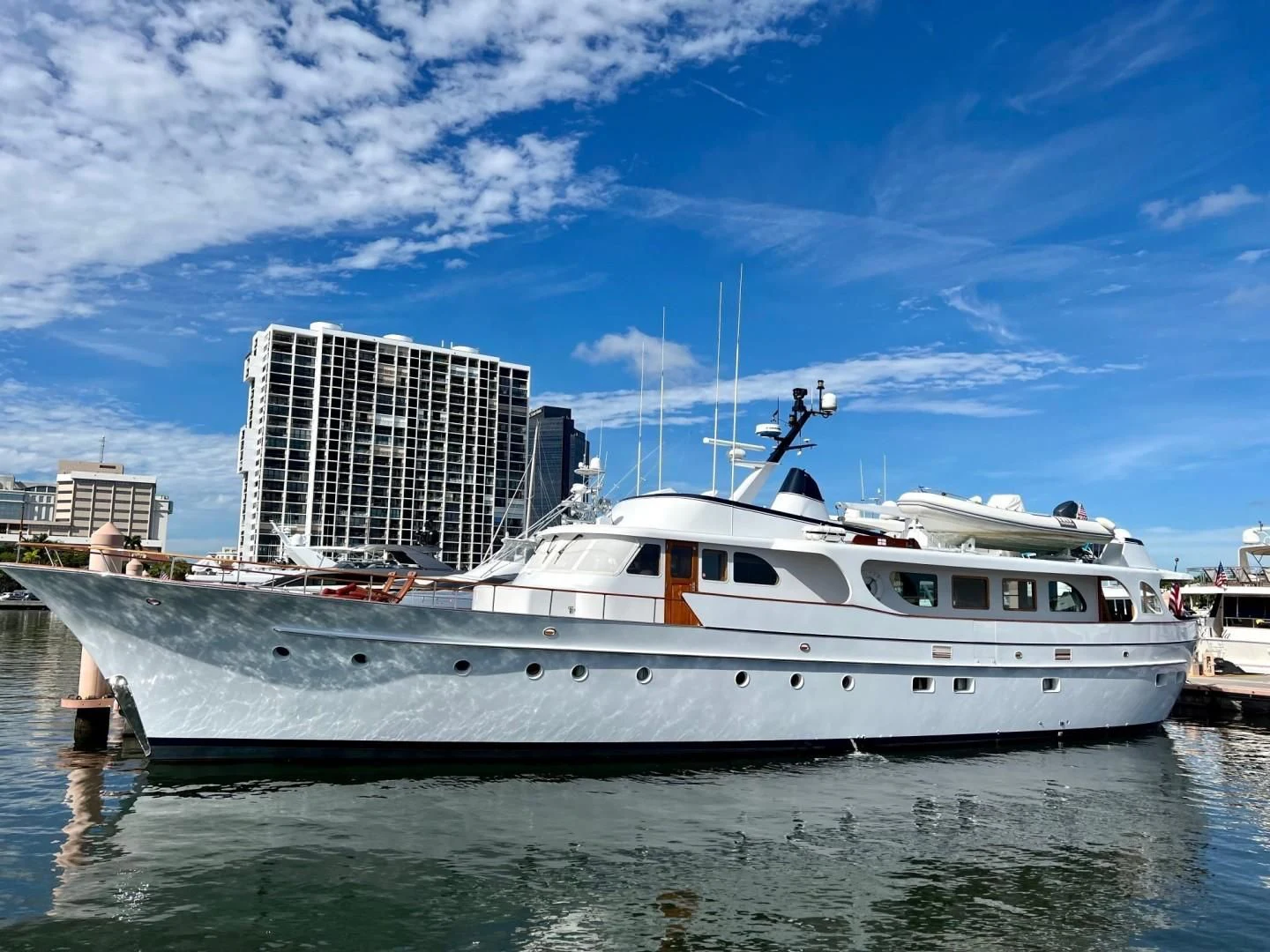 a large white boat in a harbor aboard SEA CZAR Yacht for Sale