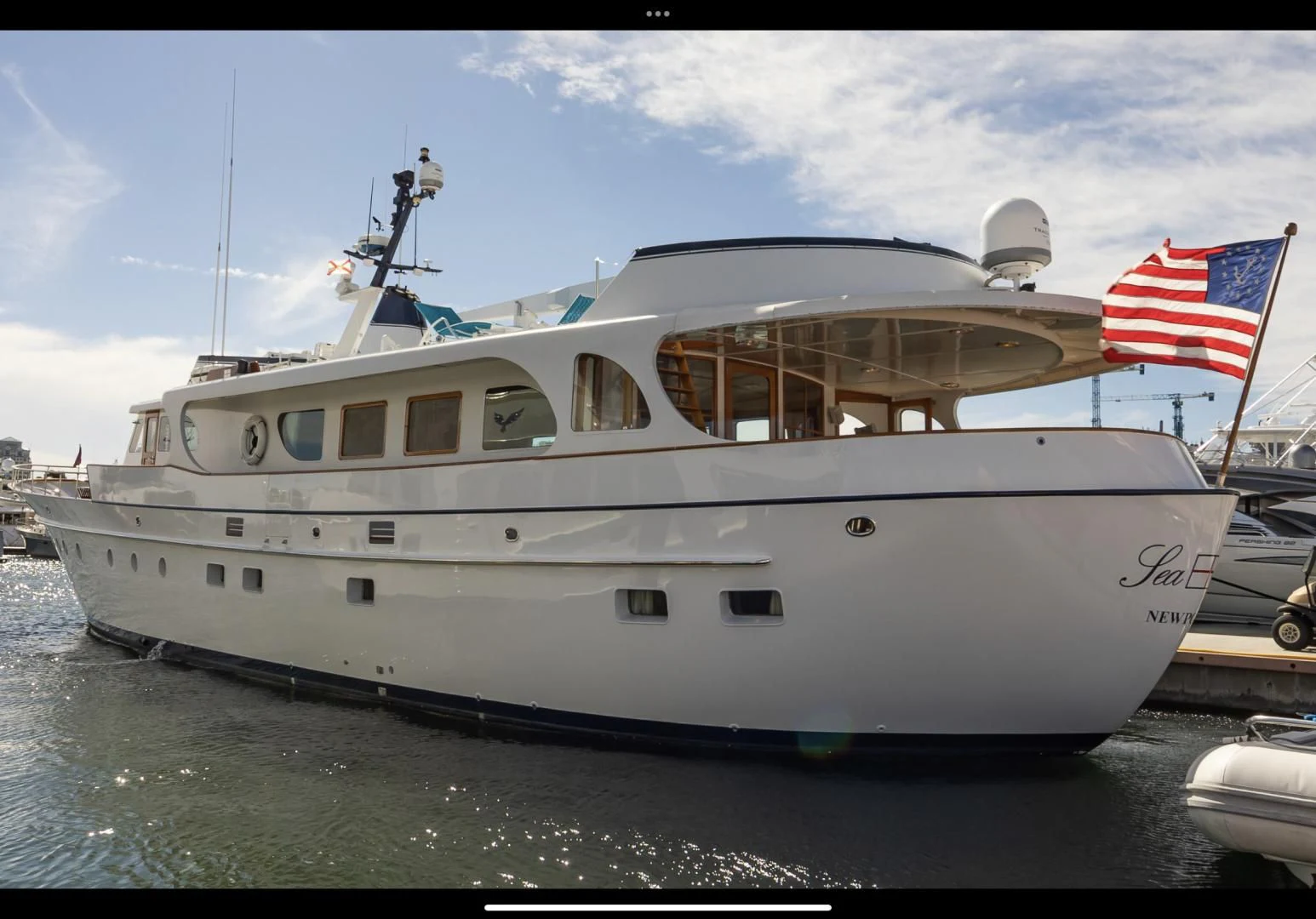 a large white boat with a flag on it aboard SEA CZAR Yacht for Sale