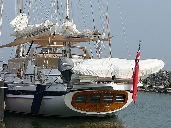 a boat with a red sail aboard IMPRESSION Yacht for Sale