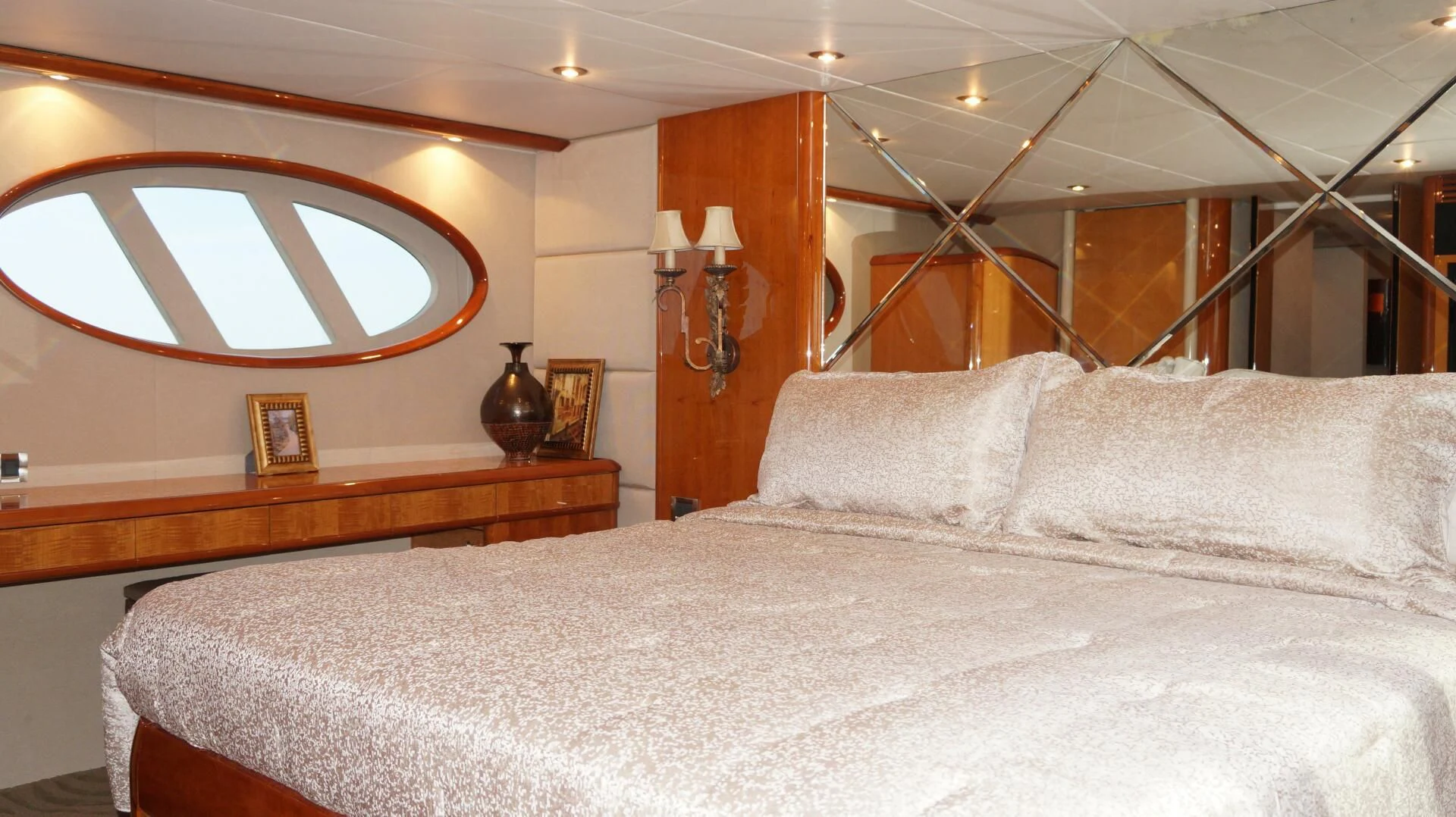 a large bed with a white comforter and a round mirror above it aboard KATHLEEN Yacht for Sale