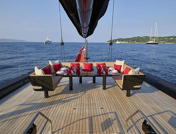 a deck with chairs and tables on it by a body of water aboard V Yacht for Sale