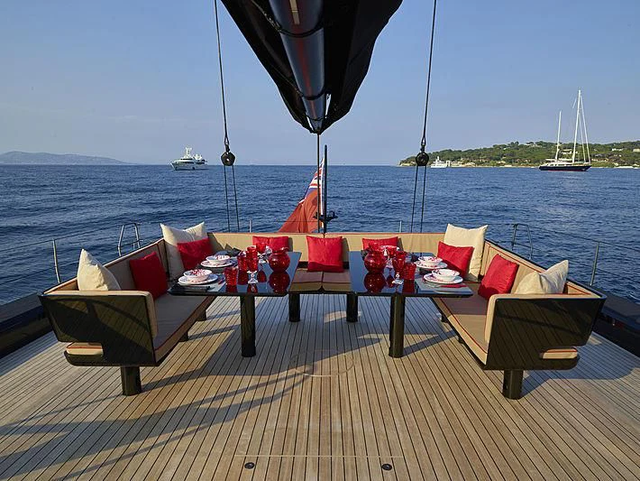 a deck with chairs and tables on it by the water aboard V Yacht for Sale
