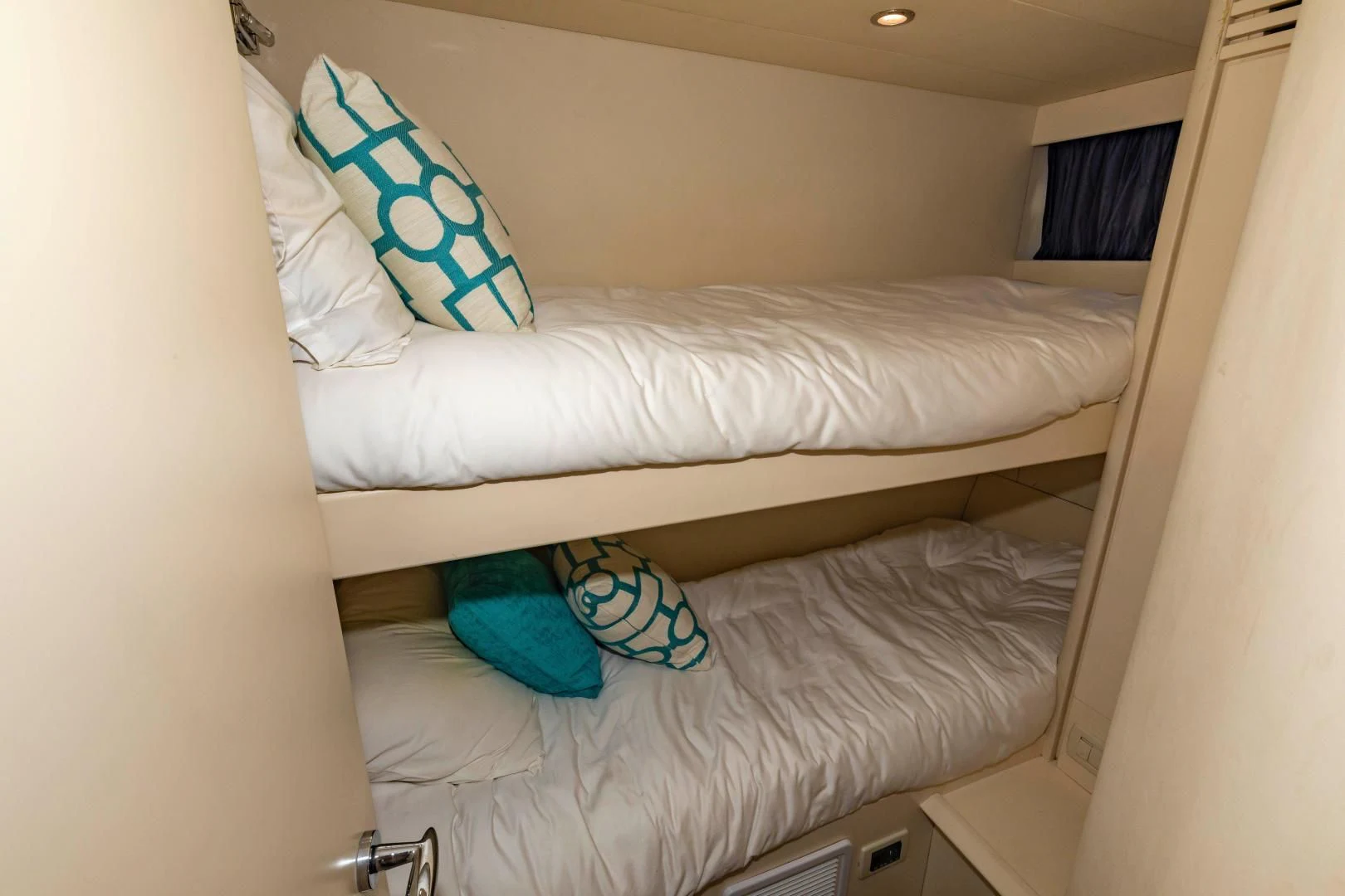 a bed with white sheets and blue pillows aboard FREE SPIRIT Yacht for Sale