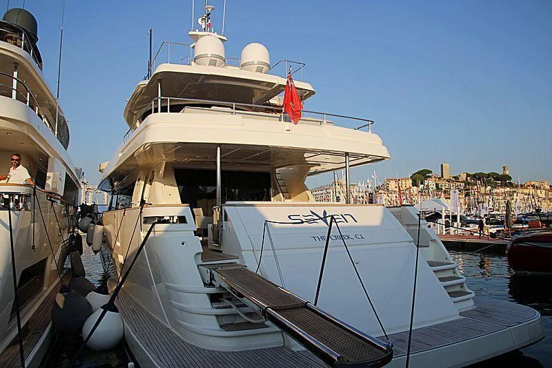 a large white boat sits in a harbor aboard SEVEN Yacht for Sale