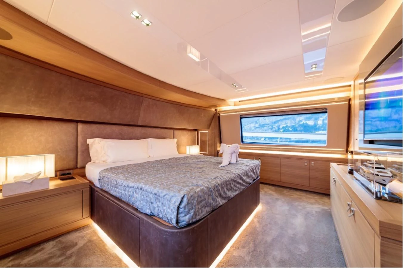 a bedroom with a bed and a window aboard SEVEN Yacht for Sale