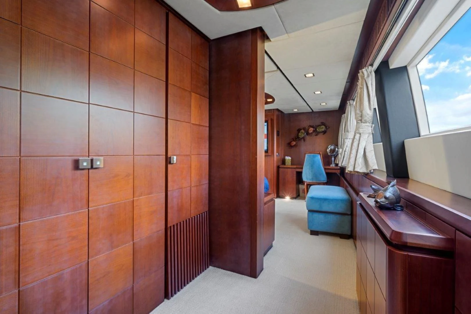 a room with a wood door and a desk with a chair and a window aboard VIVERE Yacht for Sale