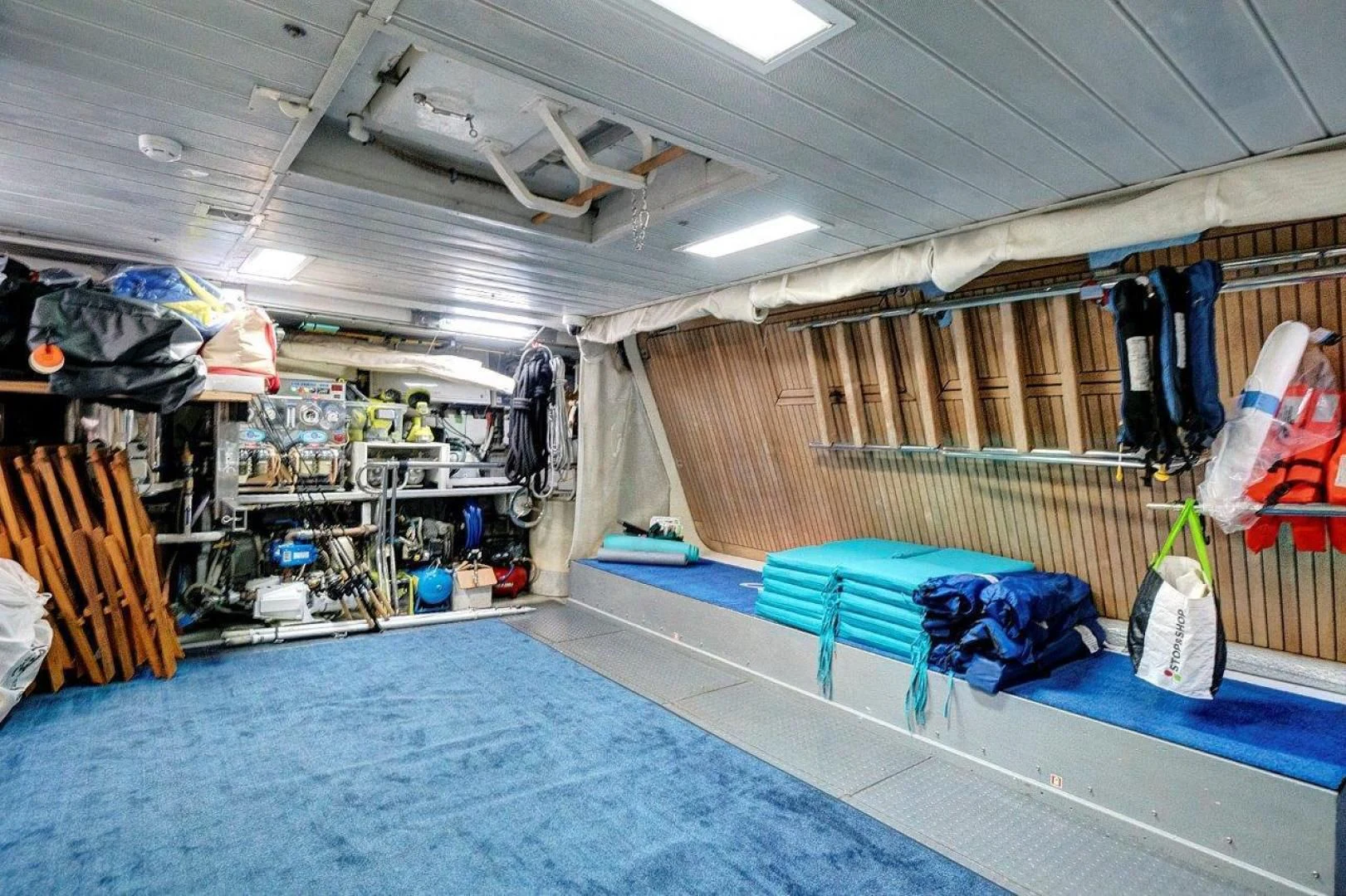 a room with bunk beds and clothes on the wall aboard VIVERE Yacht for Sale