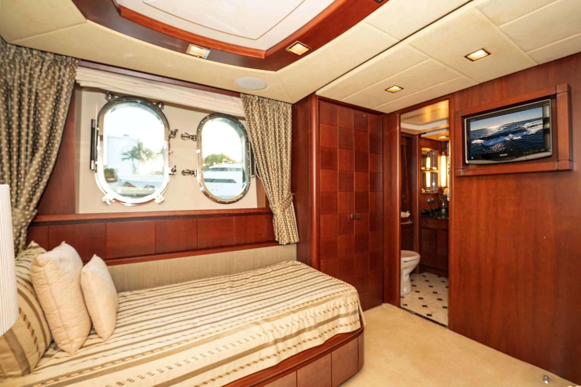 a bedroom with a bed and a mirror aboard VIVERE Yacht for Sale