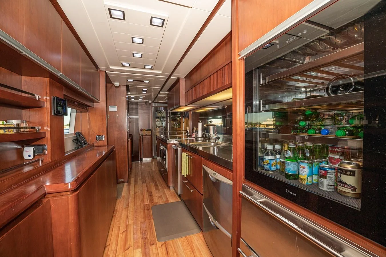 a large kitchen with a lot of bottles on shelves aboard VIVERE Yacht for Sale