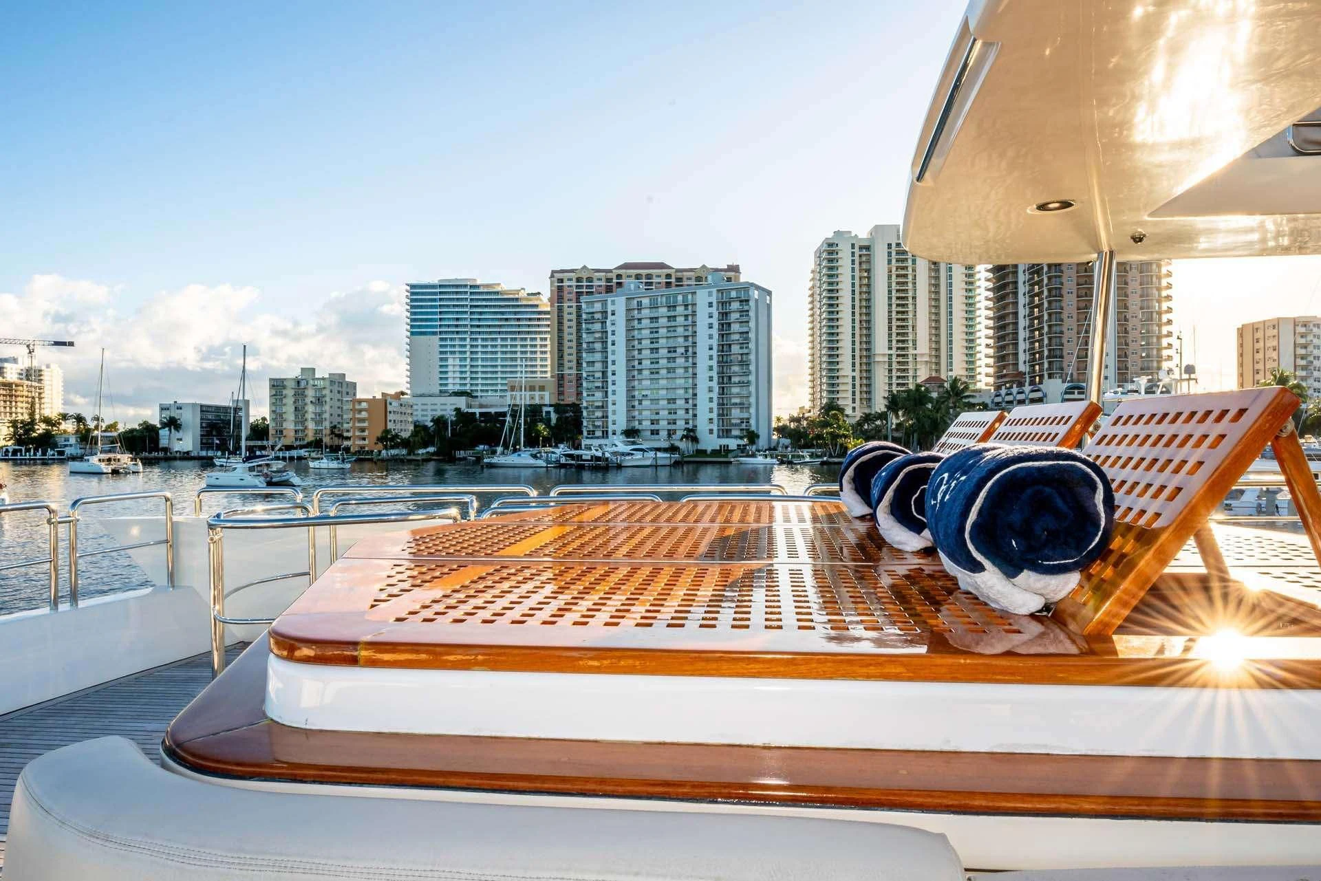 a pair of sunglasses on a deck overlooking a city aboard VIVERE Yacht for Sale