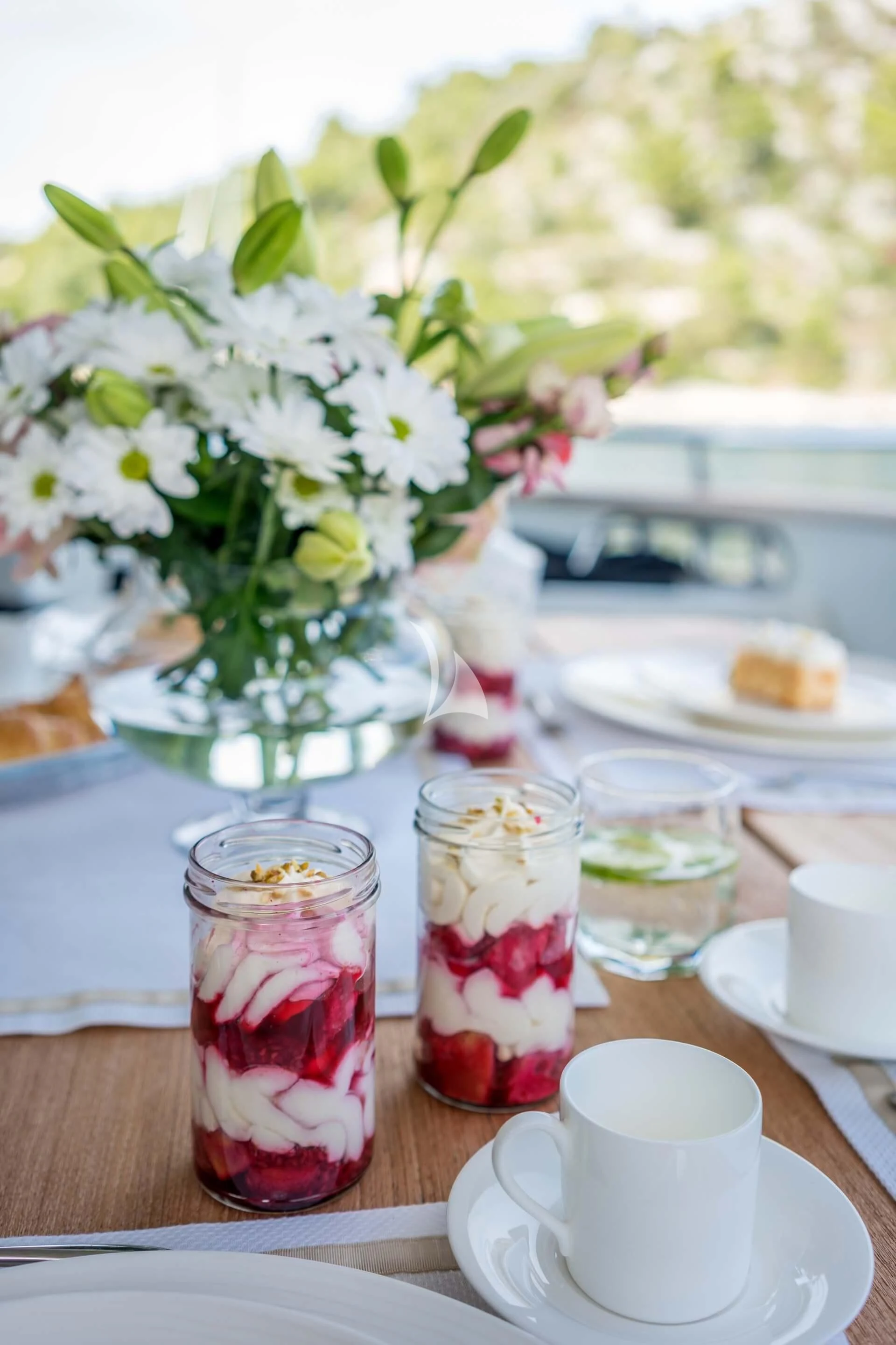 a table with a vase of flowers and a cup of tea aboard JANTAR Yacht for Charter