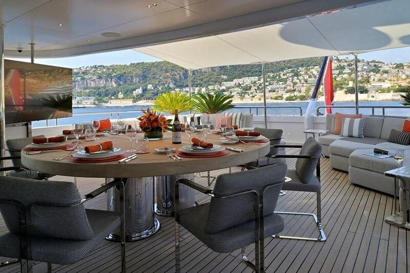 a table set with chairs and a large umbrella aboard SEAHORSE Yacht for Sale