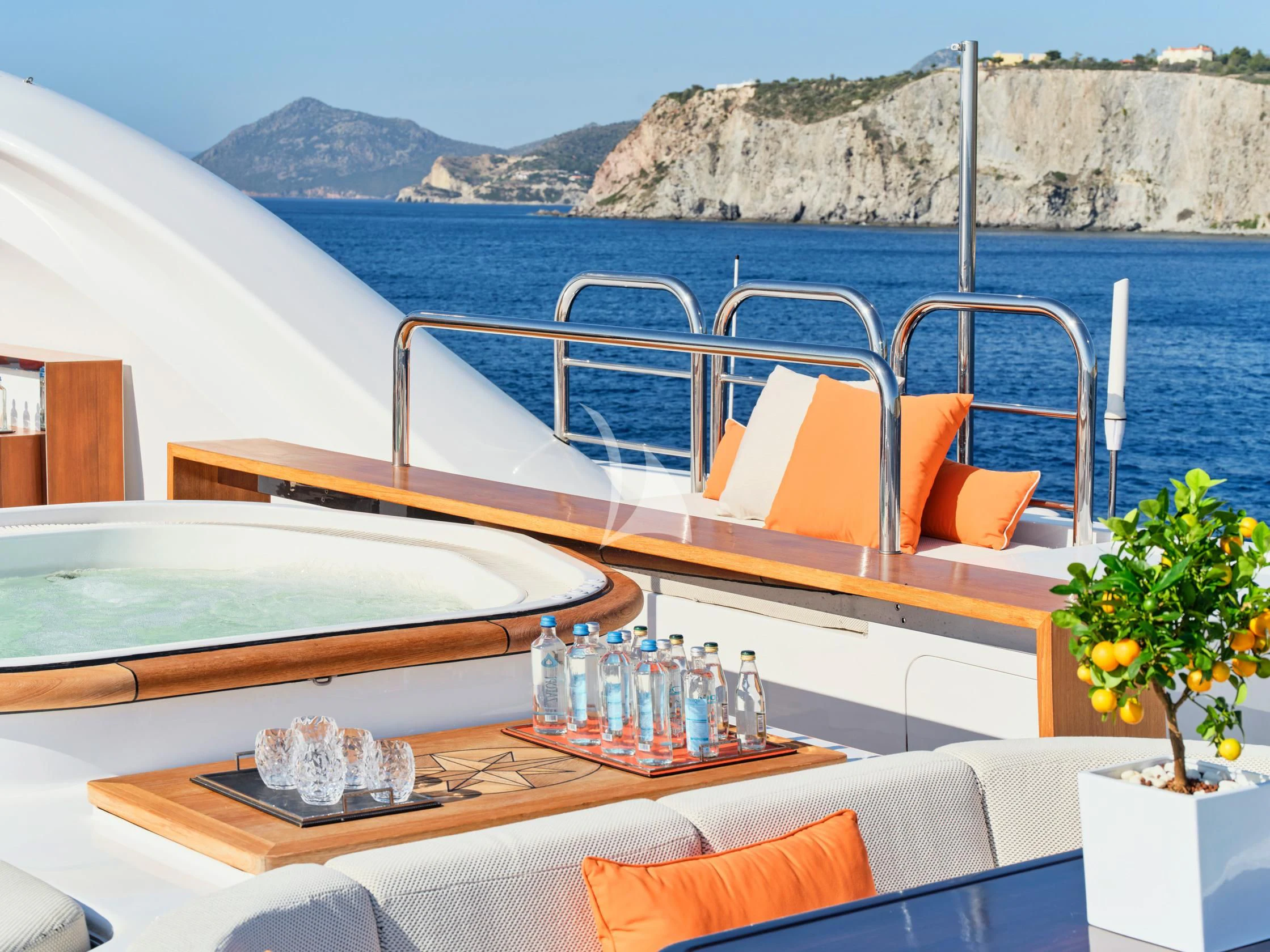 a table with bottles and glasses on it next to a large body of water aboard SEAHORSE Yacht for Sale