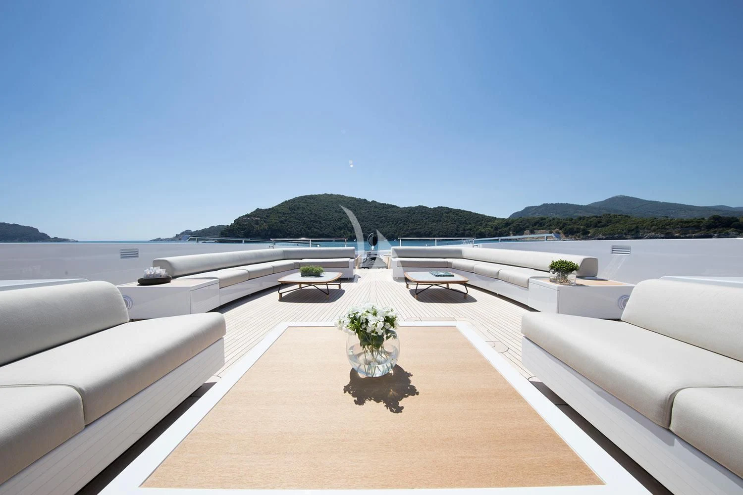 a large white room with a plant on a table and chairs on the side of it aboard SEVEN SINS Yacht for Sale