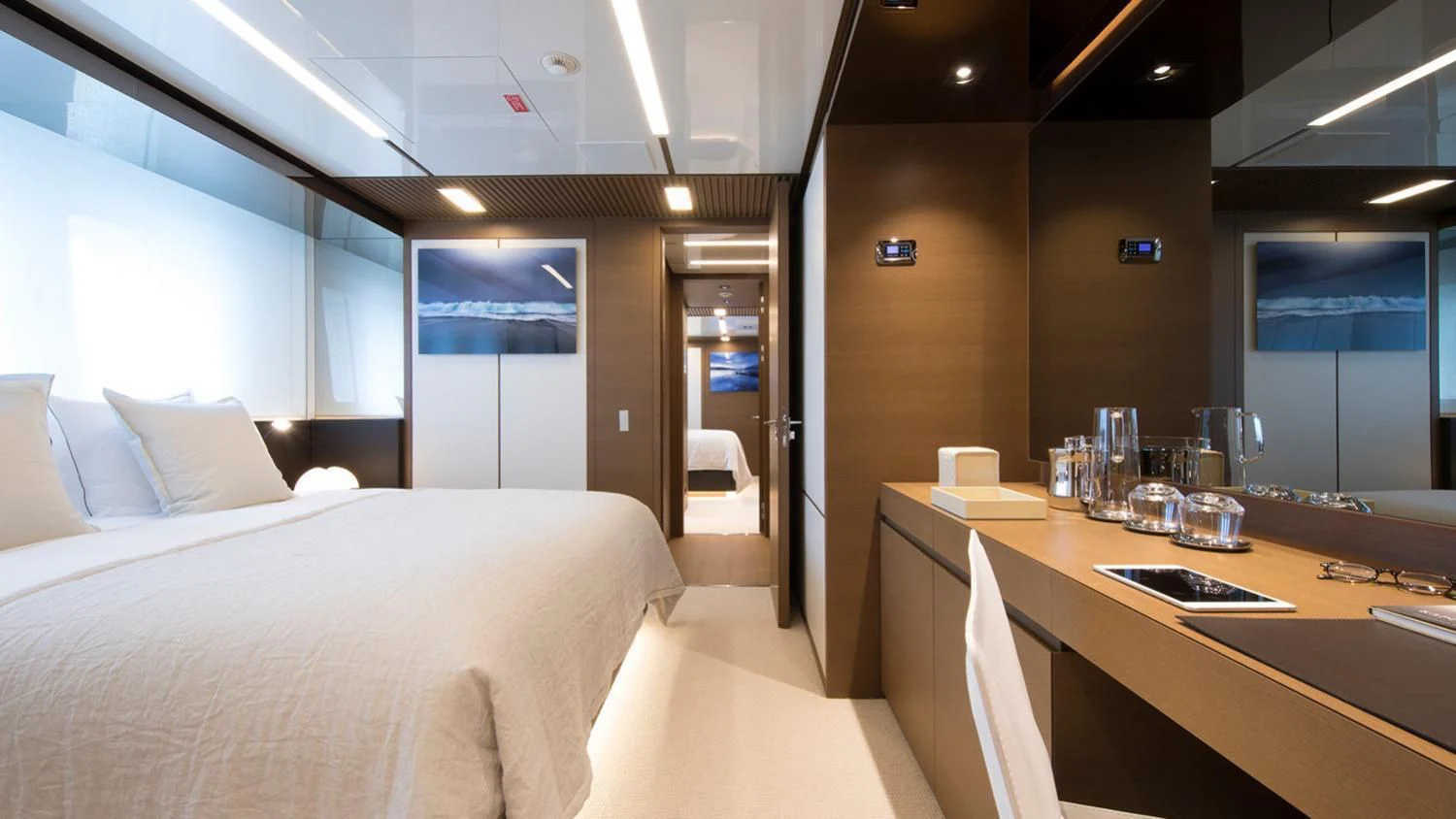 a hotel room with a desk and bed aboard SEVEN SINS Yacht for Sale