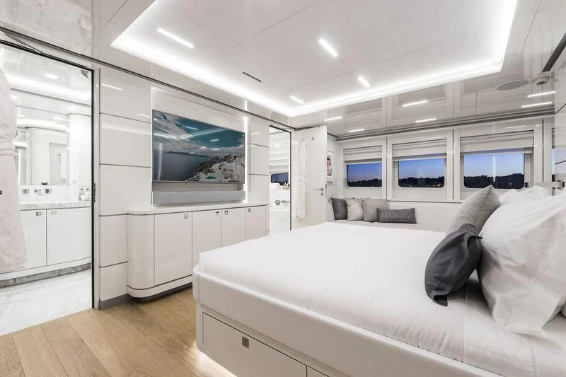a white bedroom with a large bed aboard ANGKALIA Yacht for Sale