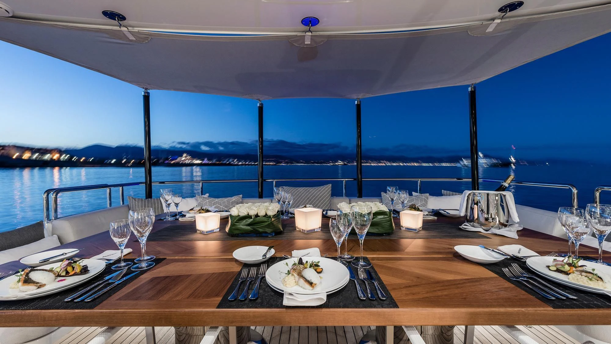 a table with plates and glasses on it aboard ANGKALIA Yacht for Sale