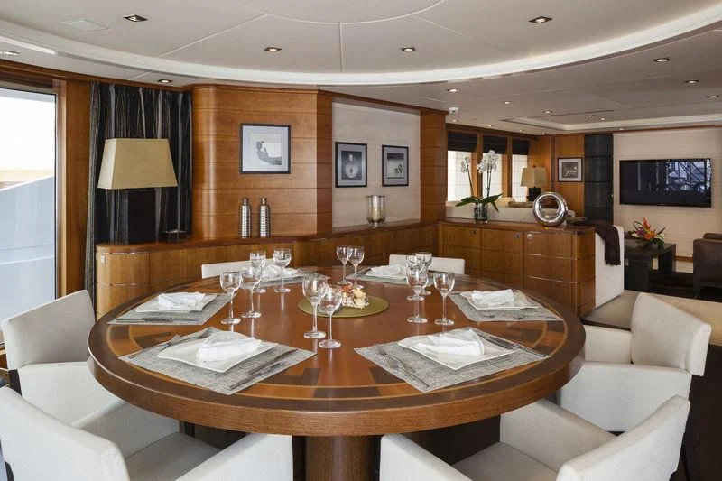 a large dining table with wine glasses aboard ANGKALIA Yacht for Sale