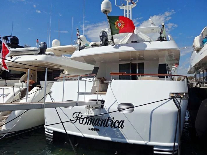 a white boat with flags on it aboard ROMANTICA Yacht for Sale