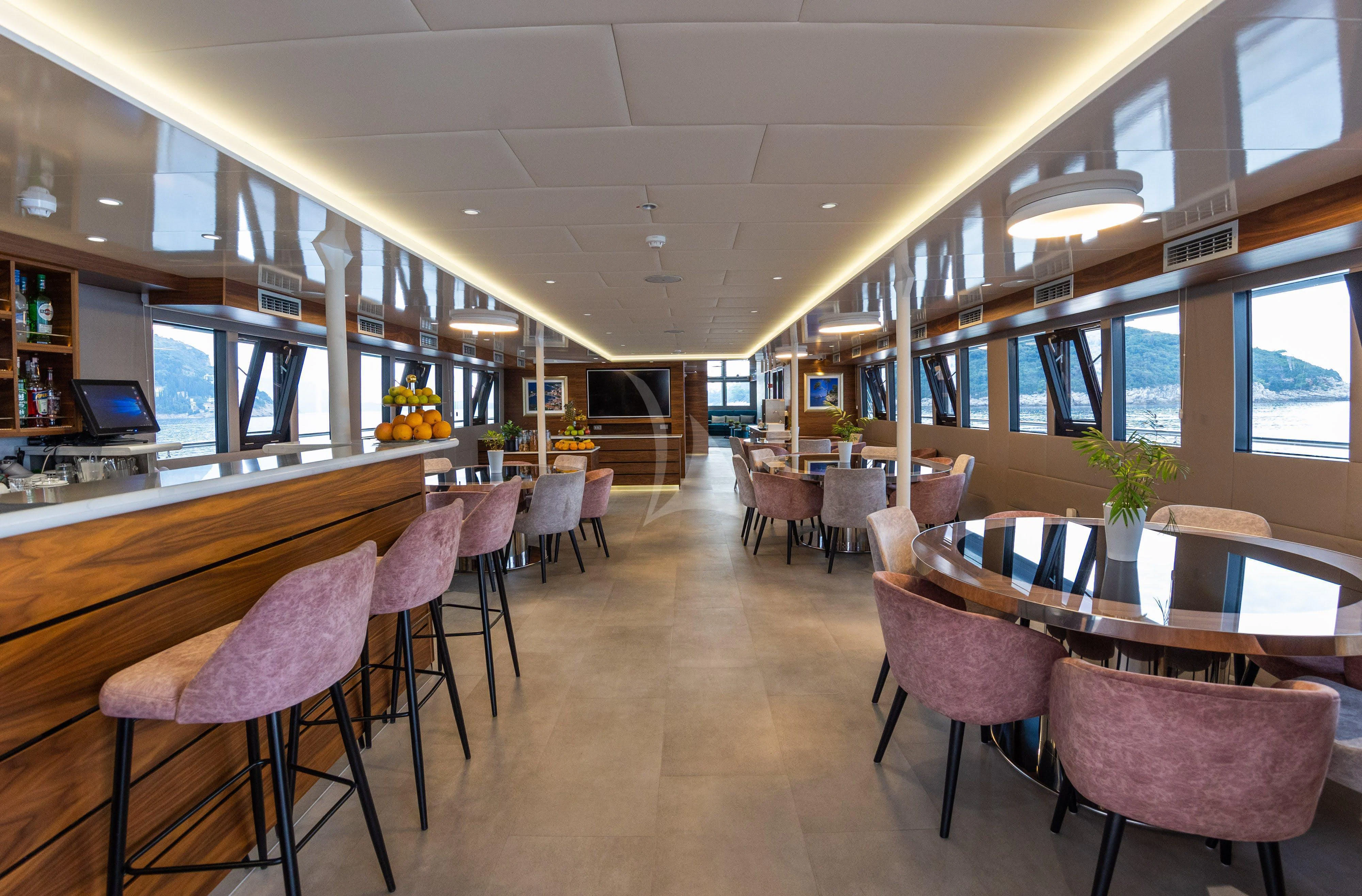 a room with tables and chairs aboard LADY ELEGANZA Yacht for Sale