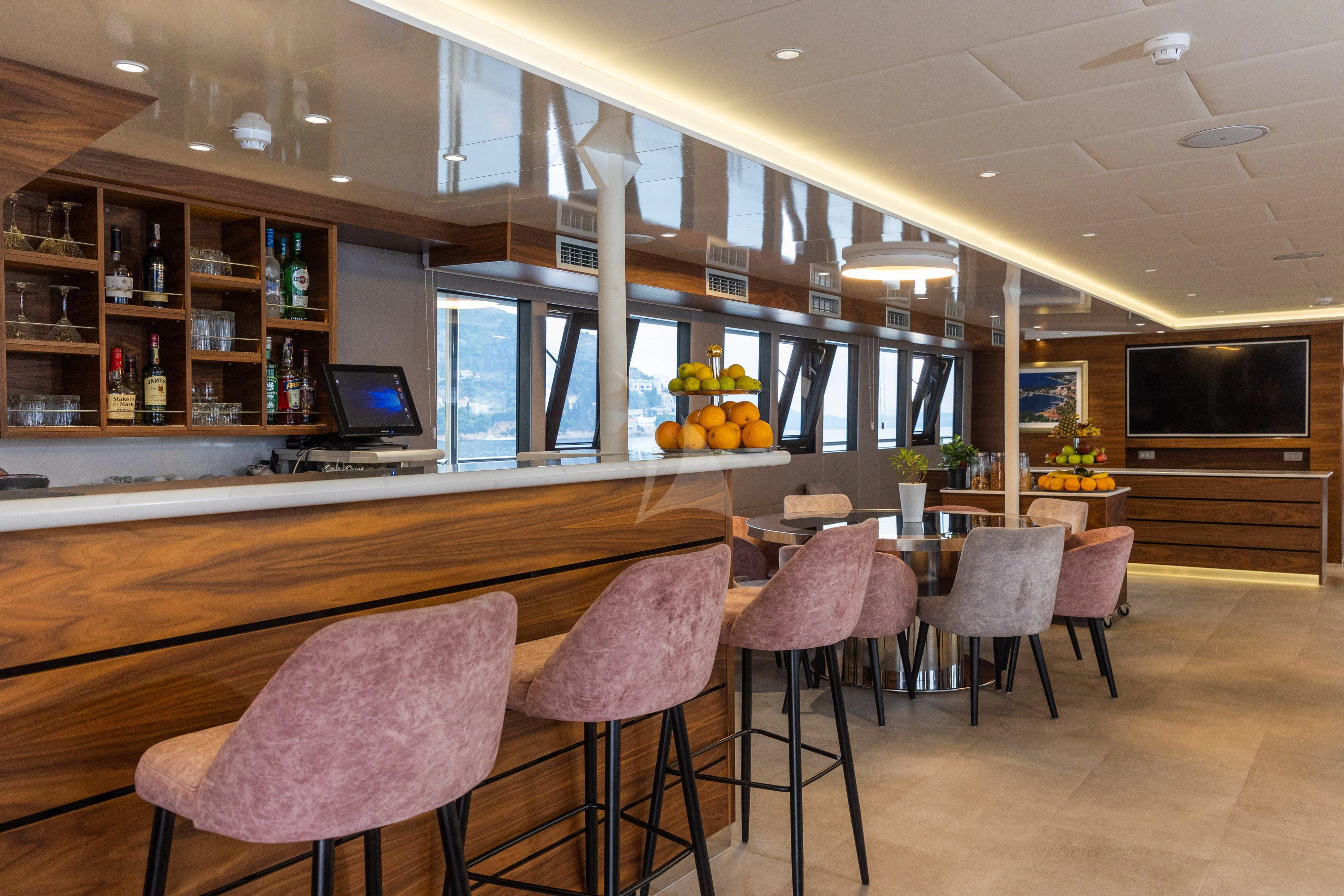 a room with a table and chairs aboard LADY ELEGANZA Yacht for Sale
