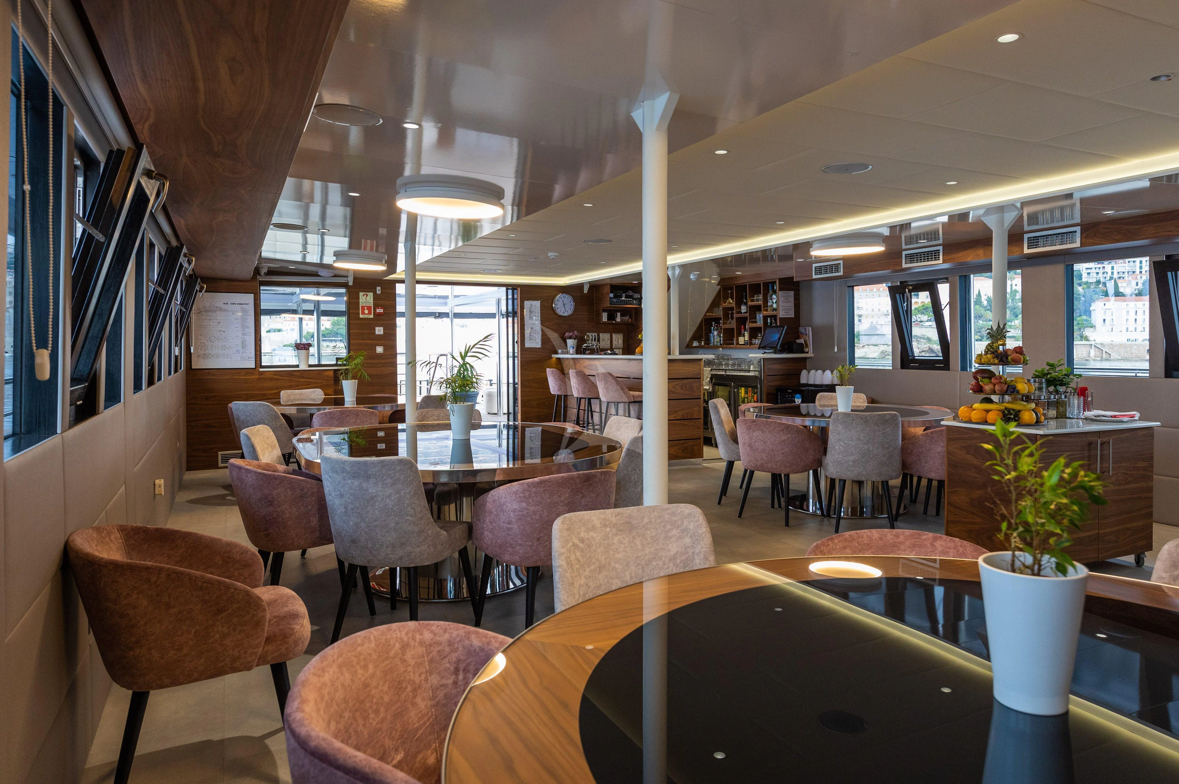 a restaurant with tables and chairs aboard LADY ELEGANZA Yacht for Sale
