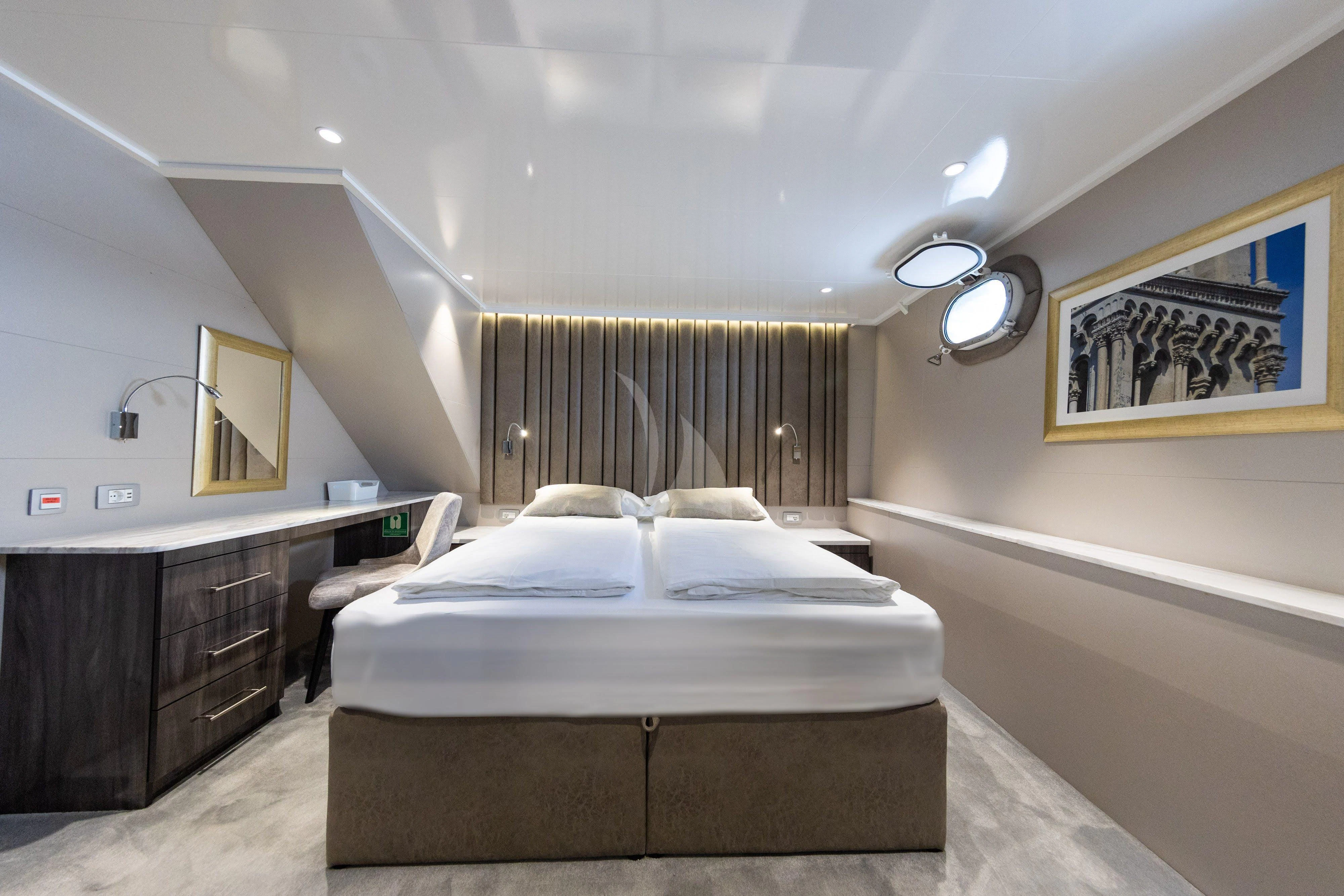 a bedroom with a bed and a desk aboard LADY ELEGANZA Yacht for Sale