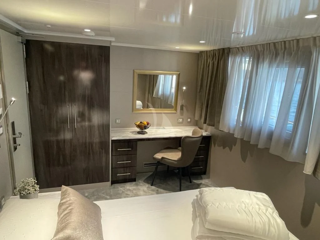 a bedroom with a desk and a bed aboard LADY ELEGANZA Yacht for Sale