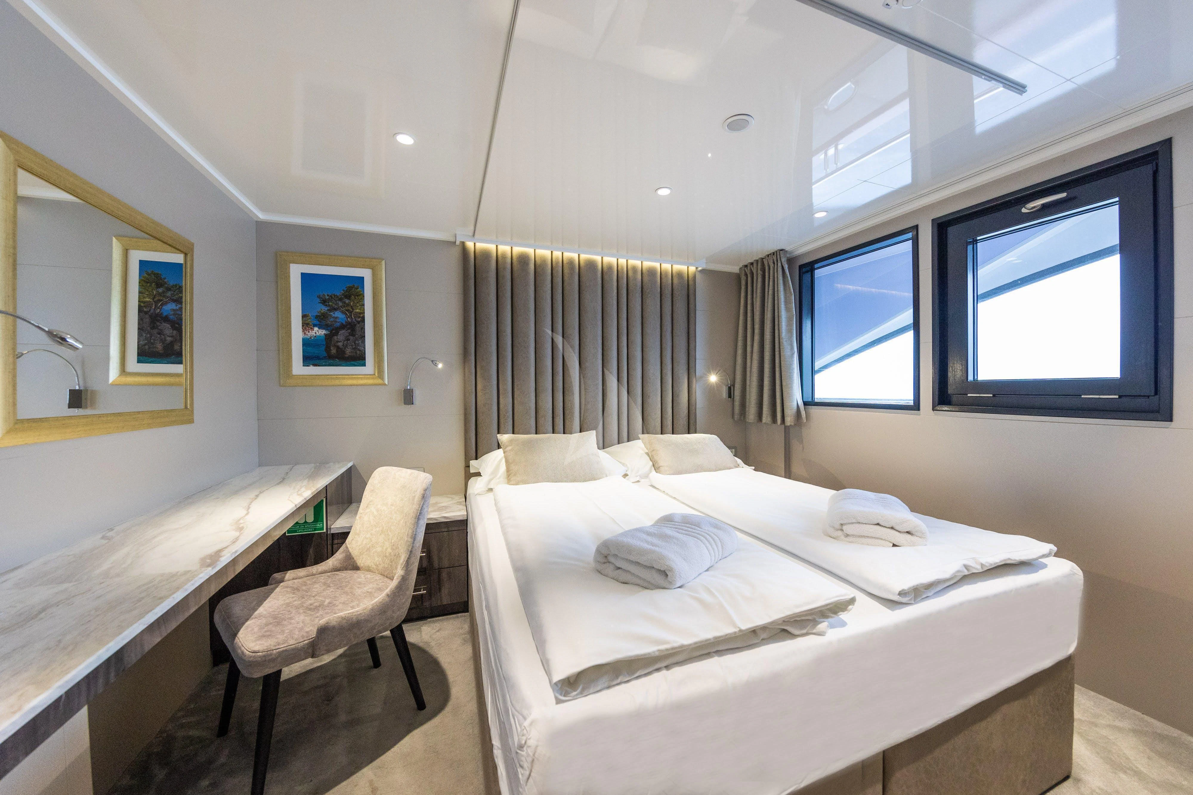 a room with a bed and a chair aboard LADY ELEGANZA Yacht for Sale