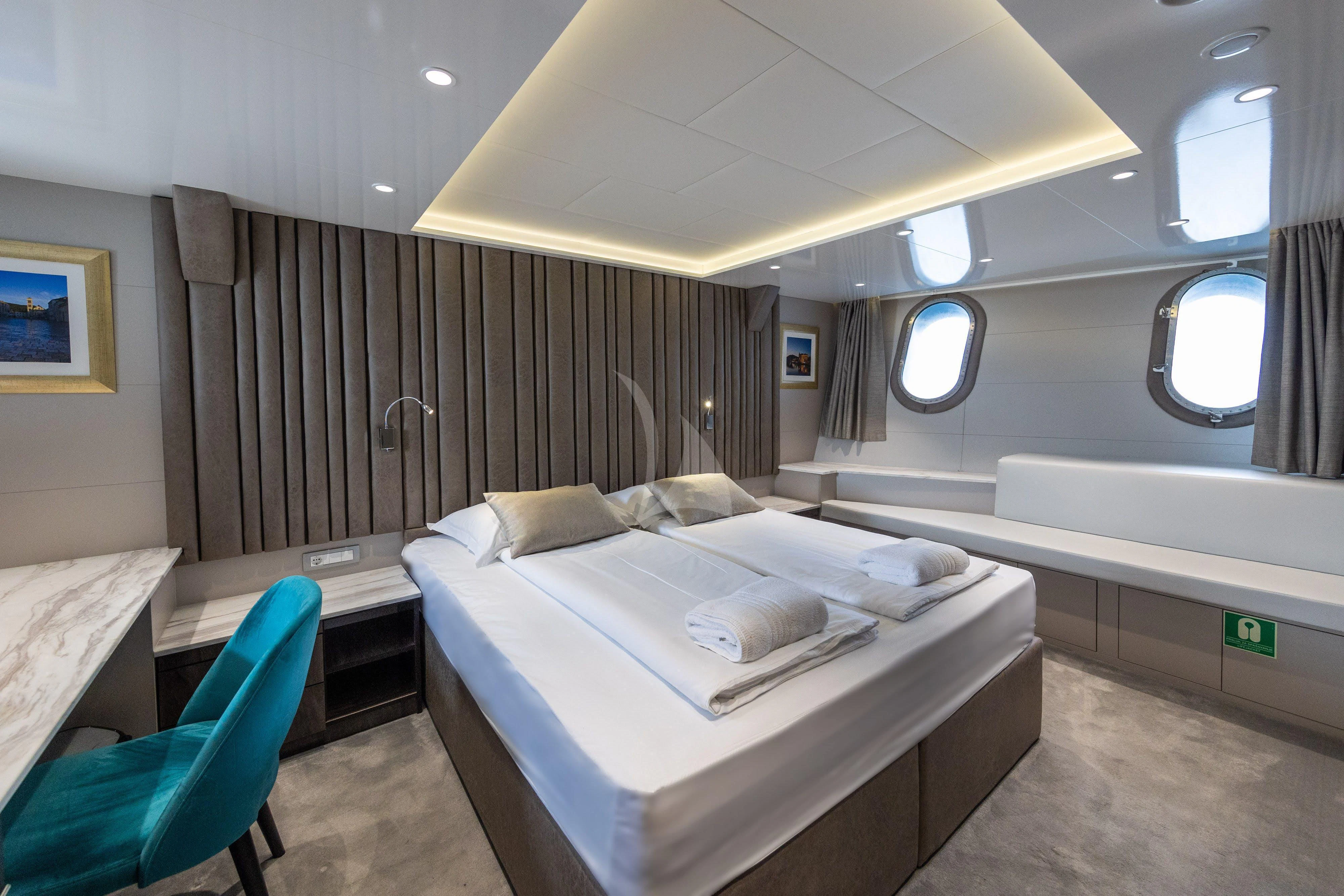 a room with a bed and a chair aboard LADY ELEGANZA Yacht for Sale