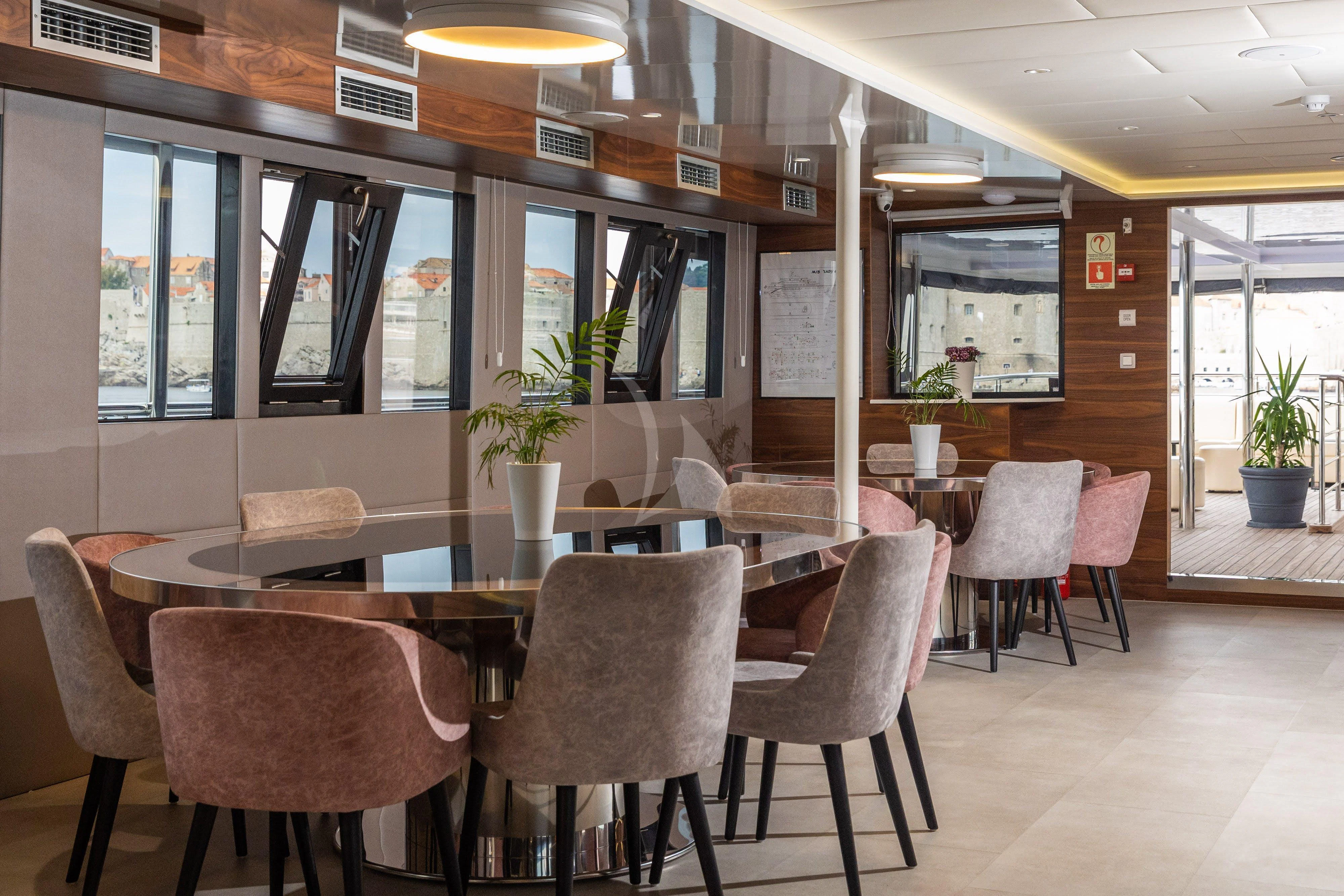 a large room with tables and chairs aboard LADY ELEGANZA Yacht for Sale