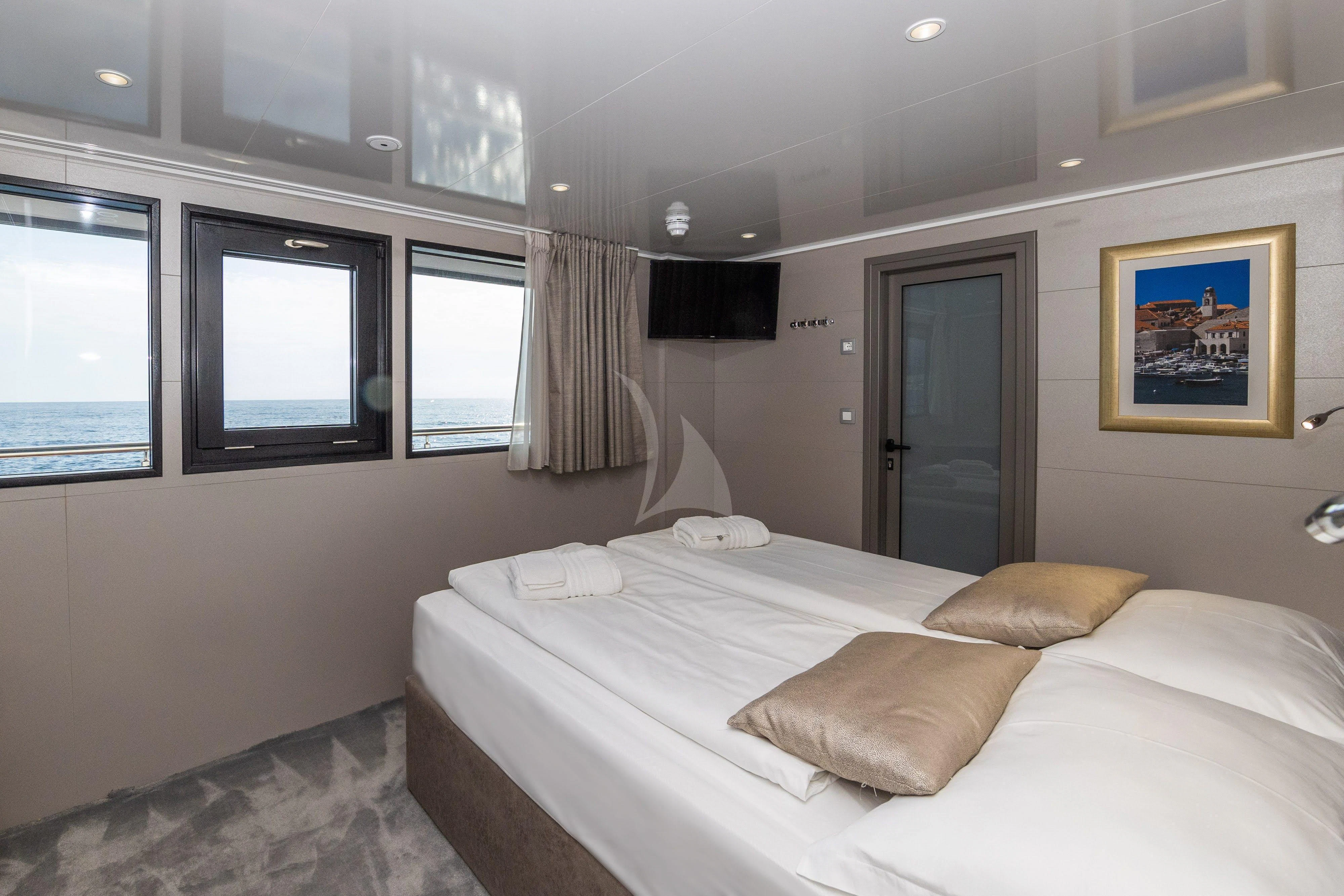 a bedroom with a bed and a window aboard LADY ELEGANZA Yacht for Sale