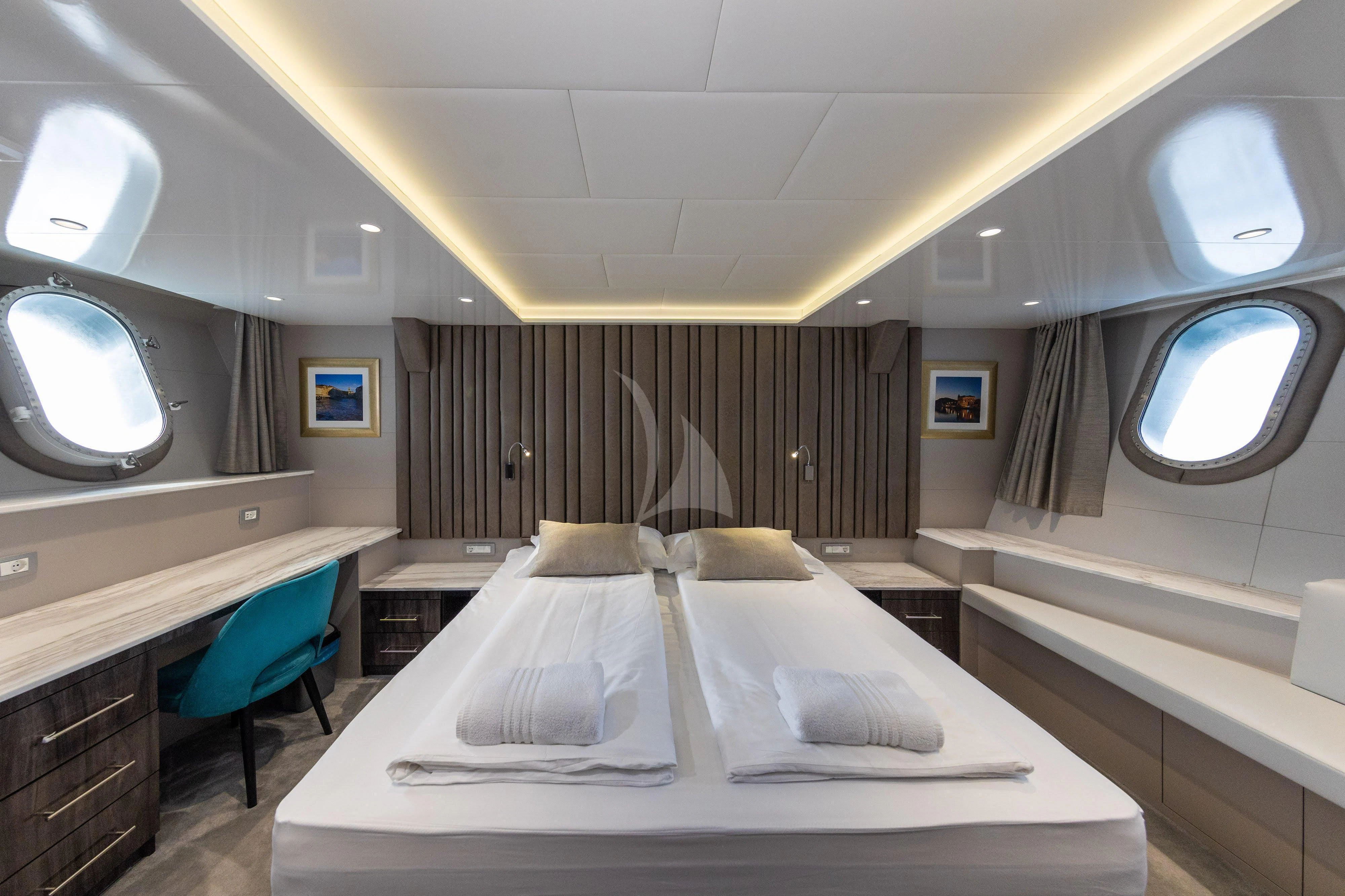 a room with a bed and a chair aboard LADY ELEGANZA Yacht for Sale