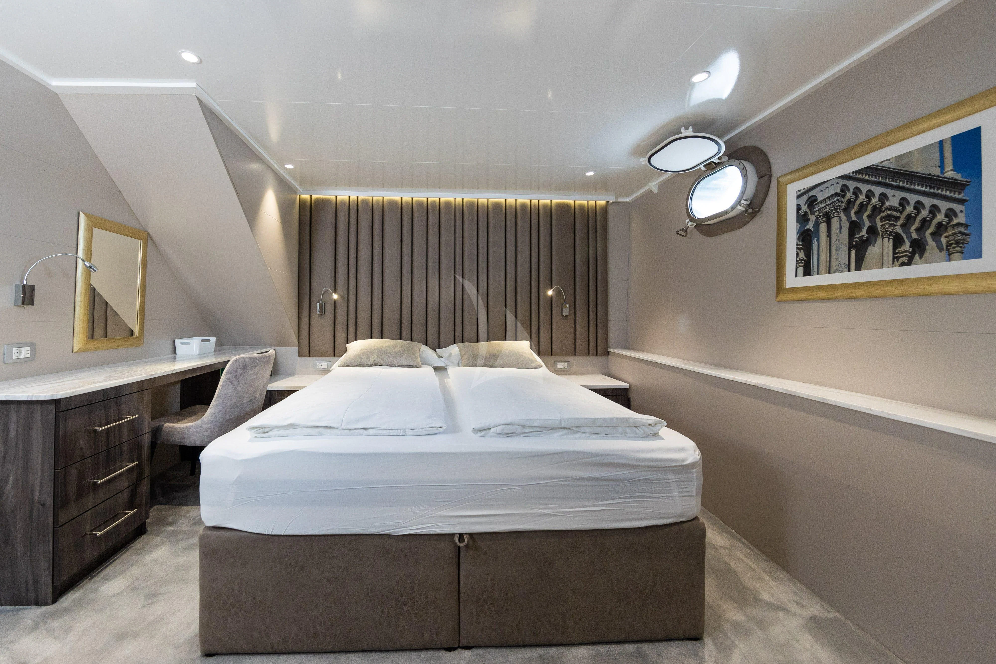 a bedroom with a bed and a desk aboard LADY ELEGANZA Yacht for Sale
