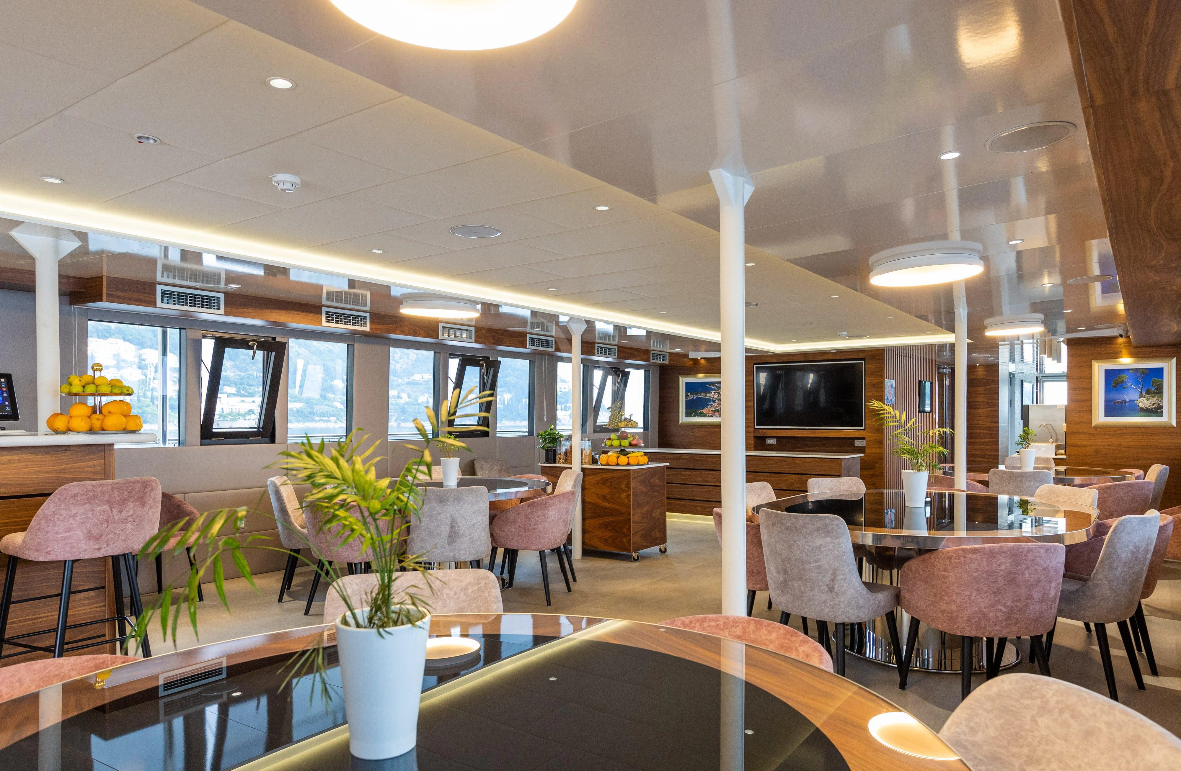 a restaurant with tables and chairs aboard LADY ELEGANZA Yacht for Sale